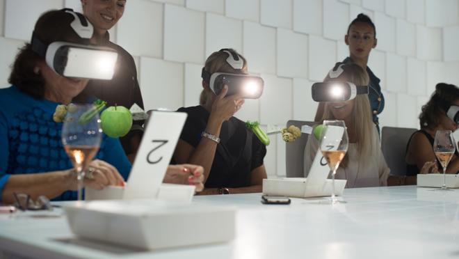 Comensales con gafas de realidad virtual a la mesa del restaurante